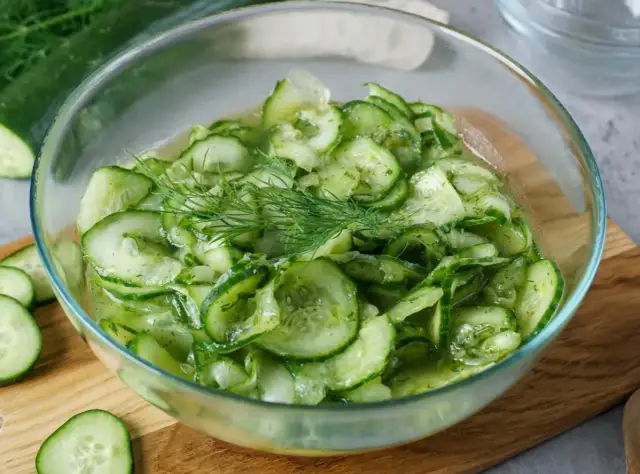 Frischer gurkensalat wie bei Oma, mit Dill garniert, in einer Glasschüssel.