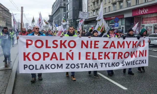 Protestujący niosą transparent "POLSKO NIE ZAMYKAJ KOPALŃ I ELEKTROWNI POLAKOM ZOSTANĄ TYLKO ŚWIECZKI". Sprzeciw wobec programu dobrowolnych odejść.