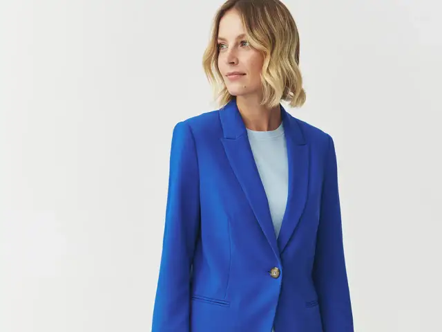 Kobieta w eleganckim żakiecie w intensywnym kolorze kobaltowym, z jasnym t-shirtem pod spodem.