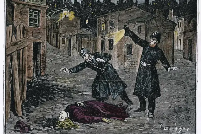Policjanci oświetlają latarniami mroczną ulicę, gdzie leży ofiara Kuby Rozpruwacza.