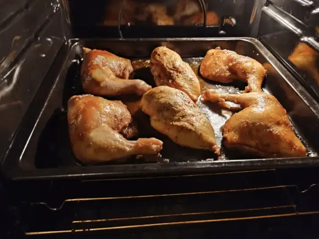 Pieczone udka i piersi z kurczaka na blasze w piekarniku.