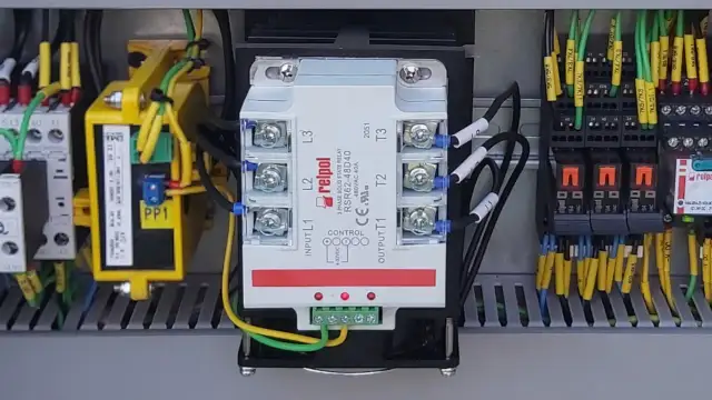 Wewnątrz szafy sterowniczej widoczny jest trójfazowy przekaźnik SSR marki Relpol, otoczony przewodami i innymi elementami elektrycznymi.