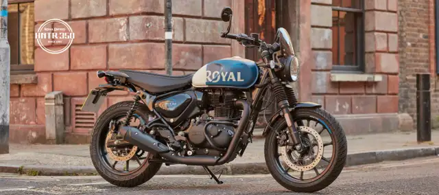 Stylowy motocykl Royal Enfield Hunter 350 z niebiesko-białym malowaniem zbiornika, zaparkowany na ulicy.