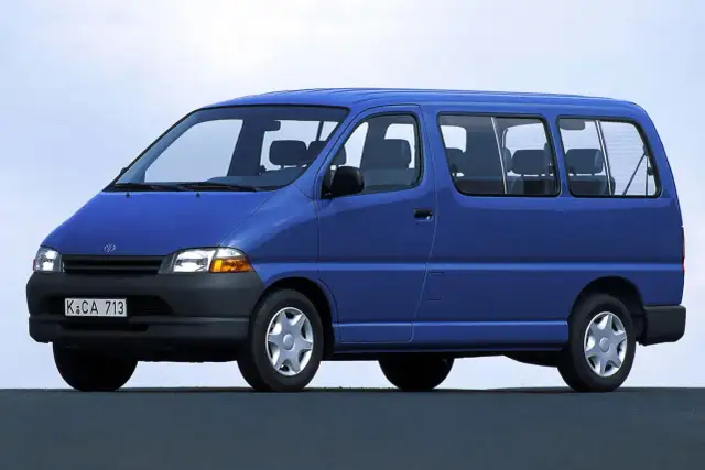 Niebieski van Toyota Hiace z lat 90. z widocznymi siedzeniami i oknami.