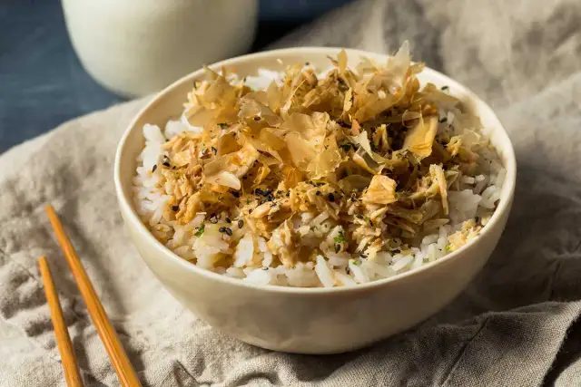 Un tazón de arroz blanco con atún desmenuzado y hojuelas de bonito seco.