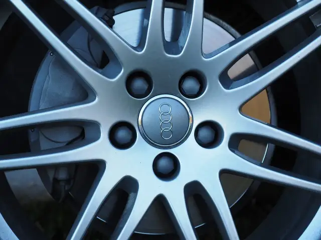 Zbliżenie na felgę Audi z widocznymi śrubami. Dowiedz się, jak zmierzyć rozstaw śrub, by dobrać odpowiednie felgi.