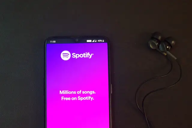 Telefon z aplikacją Spotify i słuchawkami. Idealne do słuchania wzruszających piosenek o przyjaźni.