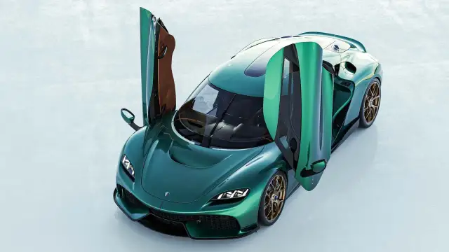 Zielony Koenigsegg Gemera z otwartymi drzwiami, prezentujący swoje luksusowe wnętrze i sportowy design.
