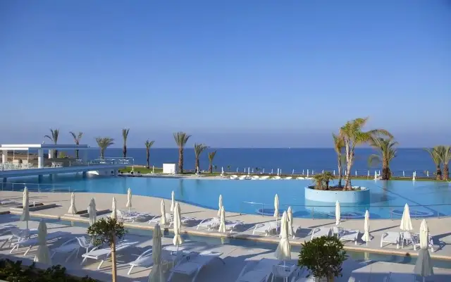Basen i plaża w King Evelthon Beach Hotel and Resort. Opinie gości potwierdzają piękno tego miejsca.
