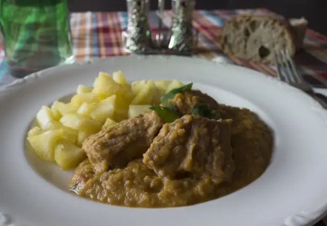 Sabrosa carne guisada con verduras y patatas, servida en un plato blanco.