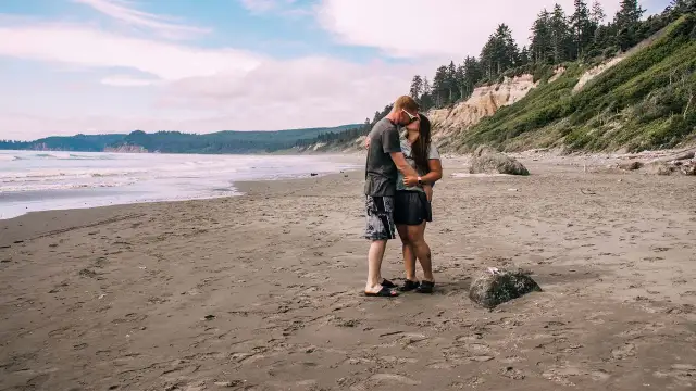 Para zapatrzona w siebie na plaży, idealny moment, by zapytać dziewczynę o związek.
