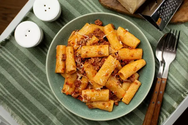 Pyszne rigatoni z sosem bolońskim, posypane parmezanem. Idealne danie, czy to rigatoni czy ziti, zawsze smakuje wybornie!