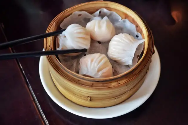 Pyszne dim sum w bambusowym parowniku, gotowe do chwycenia pałeczkami.