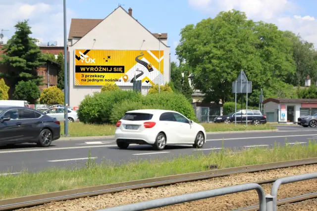 Reklama na ogrodzeniu przepisy: "Wyróżnij się 3 przekazy na jednym nośniku". Jasnożółte tło z grafiką drogi i ikonami.