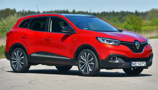 Czerwony Renault Kadjar na drodze, z widocznym przodem i bokiem samochodu.