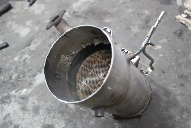 Filtr cząstek stałych, czyli DPF, z widocznym w środku ceramicznym wkładem o strukturze plastra miodu.