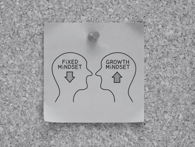 Dwie głowy, jedna z "fixed mindset" i strzałką w dół, druga z "growth mindset" i strzałką w górę. Pokazuje, co ile lat zmienia się charakter człowieka.