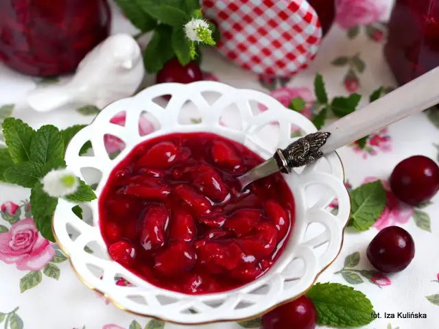 Aksamitna frużelina z wiśni w ozdobnej miseczce, ozdobiona miętą i świeżymi owocami.