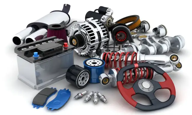 Gros plan sur un assortiment de pièces automobiles : batterie, filtres, bougies, amortisseurs, volant, etc.