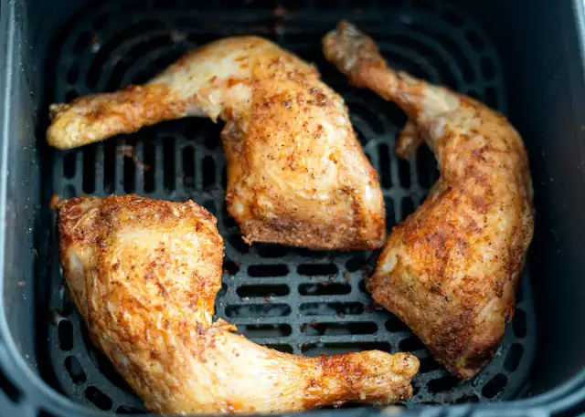 Trozos de pollo dorados y jugosos en la freidora de aire, listos para disfrutar.