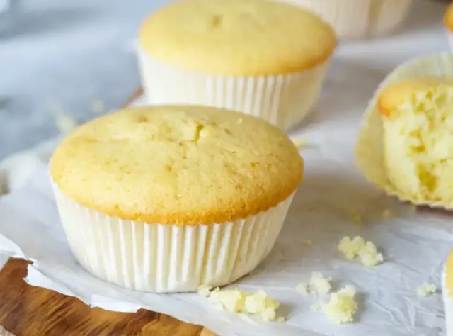 Zarte Muffins, perfekt für das Muffins Grundrezept. Einer ist angeschnitten und zeigt die fluffige Textur.