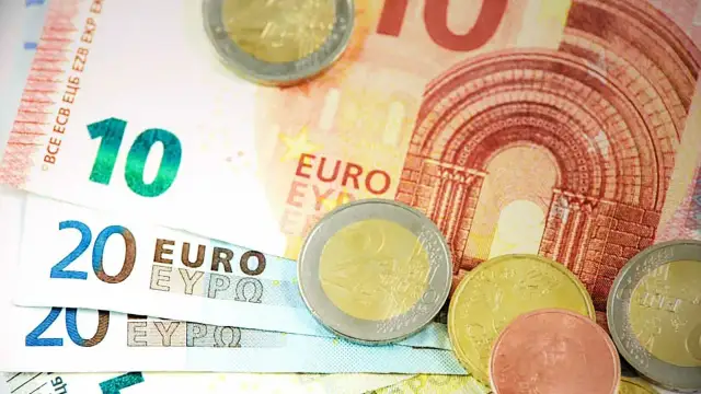 Euro banknoty o nominałach 10 i 20 oraz monety. Obrazek symbolizuje wskaźnik ogólnego zadłużenia.