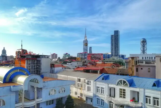 Widok na nowoczesne budynki i dachy w Batumi, stolicy Adżarii. W tle wysokie wieżowce i charakterystyczna wieża.