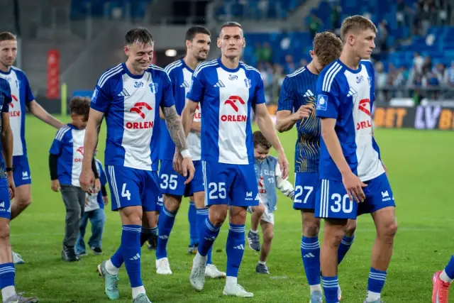 Piłkarze Wisły Płock w niebiesko-białych strojach, gotowi do rozgrywek.