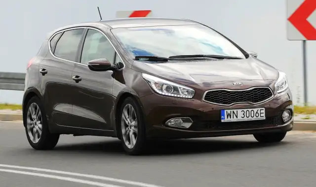 Brązowy Kia Ceed 1.6 CRDi jedzie po drodze.
