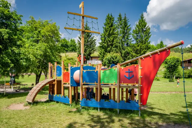 Kolorowy plac zabaw w kształcie statku pirackiego, oferujący mnóstwo atrakcji dla dzieci w Brzegu. Idealne miejsce na letnie zabawy.