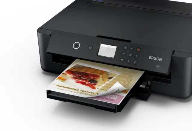 Czarna drukarka Epson drukuje ulotkę z sernikiem. Dowiedz się, jak sparować drukarkę Epson z telefonem, by drukować bezprzewodowo.