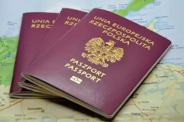 Trzy polskie paszporty leżą na mapie.