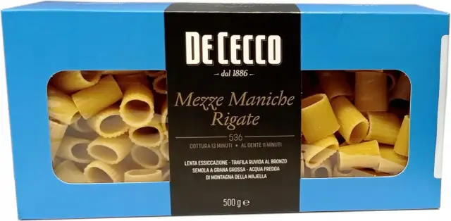Pudełko makaronu De Cecco Meze Maniche Rigate, z widocznym przez okienko makaronem. Wybór między Makaron Barilla czy De Cecco?
