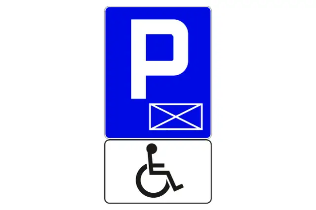 Znak P z kopertą i symbolem wózka inwalidzkiego. To indywidualne miejsce parkingowe dla osoby niepełnosprawnej.