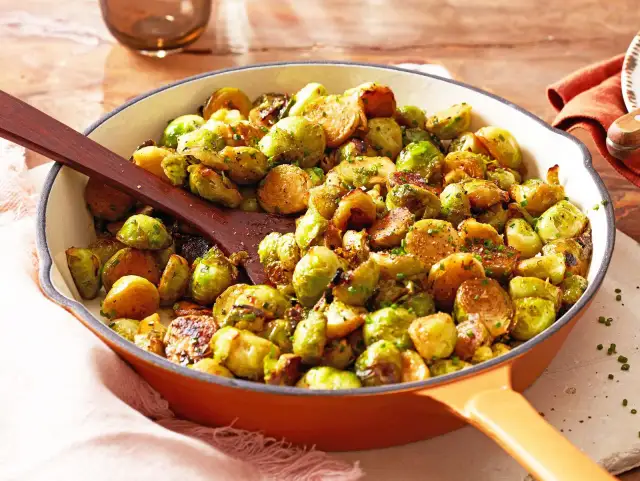 Leckere Rosenkohl Rezepte Pfanne mit gebratenem Rosenkohl und Kräutern, serviert in einer gusseisernen Pfanne.