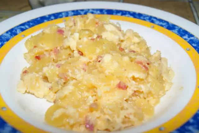Patatas revueltas con huevo y trocitos de bacon, un plato casero delicioso y reconfortante.