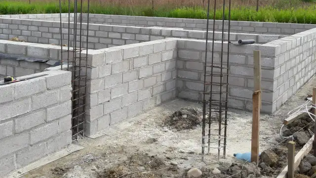 Fundament domu w budowie z bloczków betonowych i zbrojenia.