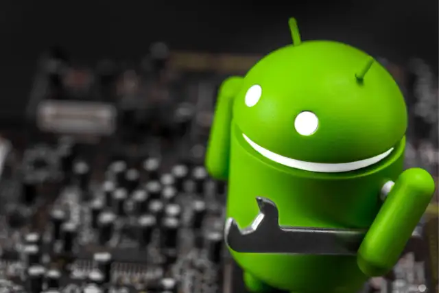 Zielony robot Android z kluczem, jakby wykryto nakładkę ekranową. W tle widać rozmazaną płytę główną.