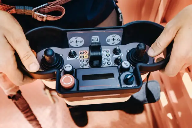Operator próbuje sterować maszyną, ale brama nie reaguje na pilota. Widoczne przyciski i joysticki panelu sterowania.