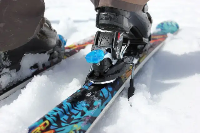 Narty z butami w śniegu. Czy snowboard jest bezpieczniejszy od nart? To pytanie zadaje sobie wielu narciarzy.