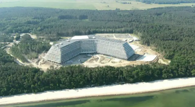 Hotel Gołębiewski Pobierowo kiedy otwarcie? Ogromny hotel w budowie na tle lasu i plaży.