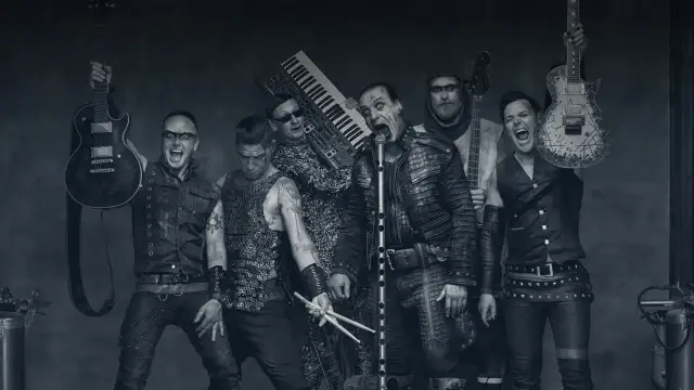 Rammstein-Bandmitglieder mit Instrumenten, schwarz-weiß.