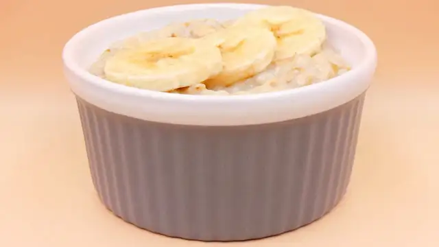 Pyszna owsianka z bananem w szarej miseczce, idealna na zdrowe śniadanie.