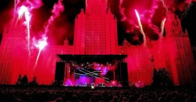 Ogromny budynek oświetlony na czerwono, fajerwerki i scena koncertowa. Tłum ludzi czeka na największy koncert na świecie.