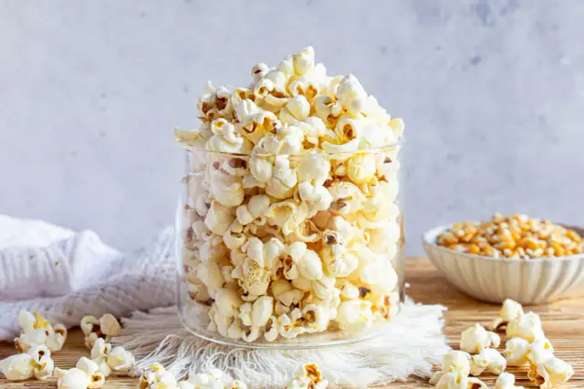 Ein Glas voller frisch gemachtem Popcorn, perfekt für einen Filmabend. So einfach ist Popcorn selber machen!