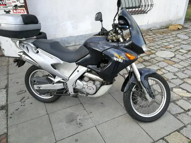 Czarny motocykl Aprilia Pegaso 650 z kufrem na bagaż, gotowy na przygodę.