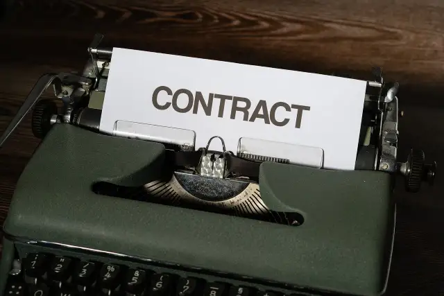 Stara maszyna do pisania z kartką z napisem "CONTRACT". Czas na wypowiedzenie umowy B2B.
