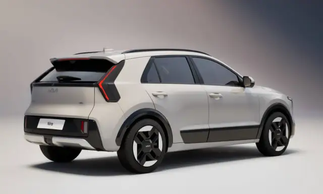Nowy Kia Niro w kolorze jasnoszarym, widok z tyłu. Stylowe, pionowe światła tylne i czarne akcenty podkreślają nowoczesny design.