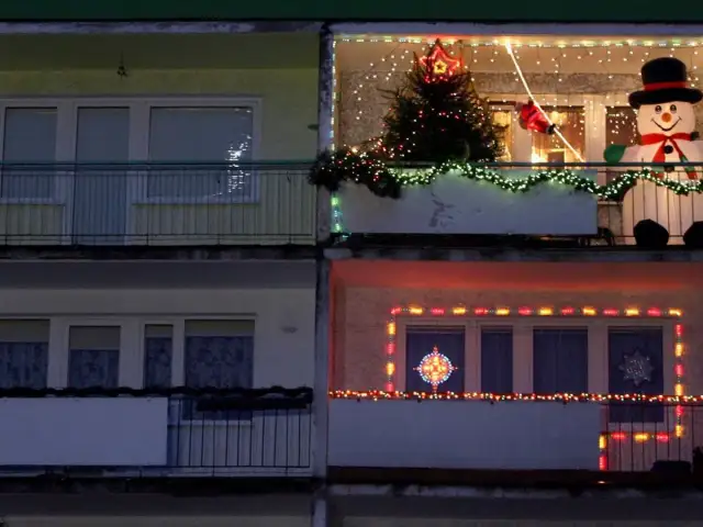 Świąteczne dekoracje na balkonach: choinka, bałwan, Mikołaj i lampki. Pomysł, jak zawiesić lampki na balkonie, by stworzyć magiczny klimat.