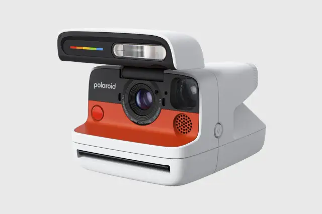 Nowoczesny aparat Polaroid z pomarańczowym akcentem i tęczowym paskiem na lampie błyskowej. To właśnie polaroid, co to za magia!